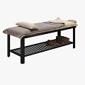 Massage Bed with Black Frame Gray Beige Blanket Pillows and Lower Shelf Stacked Towels