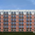 Red Brick School Building Featuring Modern Glass Elevator Shaft Greenery And People Walking