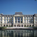 Classical Symmetrical Office Building With Water Pond Reflection And Green Lawn Exterior
