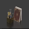 Pens in Brass Holder with Scissors Glasses and Red Decorated Book on Dark Blue Background