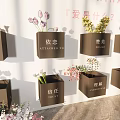 Commercial Display Equipment With Black Square Boxes And Floral Decorations On White Wall