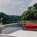 Outdoor Waterfall Pool with Red Circular Object Trees and Lake Natural Surroundings