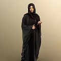 Woman Wearing Black Abaya And Hijab Standing Against Beige Background With Hand Gesture