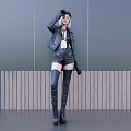 Woman Wearing Black Leather Jacket Shorts and Over Knee Boots by Gray Wooden Wall