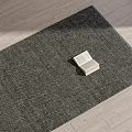 Square Rug Dark Gray Textured Design On Light Wood Floor With Book