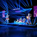 Live Stage Performance Featuring Performers Blue Lights Large Screens Guitarist Drummer And City Skyline