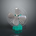 Silver Bladed Electric Fan With Green Base And Metal Guard On Dark Background