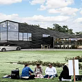 Modern Detached Villa With Black Facade Large Glass Windows And Grass Lawn
