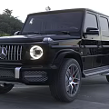 Two Black SUV Cars With Front Grille Round Headlights In Outdoor Parking Lot