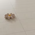 Flower Shaped Decorative Pillow with Beige Petals and Yellow Center on Light Colored Tiled Floor