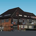 Old Red Brick Industrial Building With Black Roof And Multiple Windows