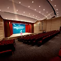 Cultural Center Auditorium Interior With Red Seats Stage Blue Screen Red Curtains And Ceiling Lights