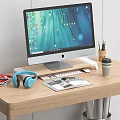 Computer Monitor Desktop Setup with Keyboard Mouse Blue Headphones Magazines Coffee Cup on Wooden Desk