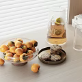 Ripe Orange Fruits in Glass Bowl on Wooden Table with Scattered Pieces and Glass Pitcher