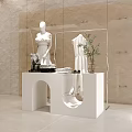 Modern White Display Shelf with Mannequin in Dress Folded Towels Sunglasses and Plant