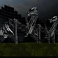 Large Solar Reflector Panels Mounted On Metal Support Structures With Green Vegetation And Blue Sky