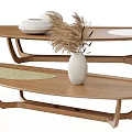Wooden oval coffee tables featuring white bowl-like objects dried pampas grass woven mat and vase
