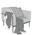 Light Gray Armchair With Chevron Pattern Pillows And Gray Blanket On Black Metal Legs