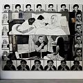 Large Black And White Art Painting With Central Figures And Surrounding Portrait Heads On Wall