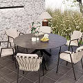 Outdoor Patio Round Table With Woven Chairs Brick Wall Table Lamp And Greenery