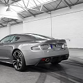 Silver Sports Car Parked In Indoor Space With White Walls Metal Roof And Tire Tracks