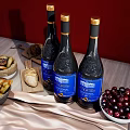 Three Dieu et Dames Wine Bottles With Wine Glasses Bread And Olives On Red Background
