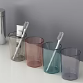 Modern Bathroom Accessories With Assorted Color Tumblers Toothbrushes And Toothpaste On White Countertop
