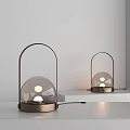 Two Modern Table Lamps With Metal Frame And Glass Globe Shade Illuminated On Shelf
