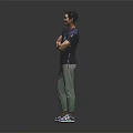 Smiling Man in Gray T Shirt and Green Pants with Arms Crossed Against Gray Background