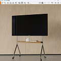 Black TV on Metal Stand with Wooden Top and Wheels Against Light Wooden Wall