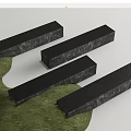 Black Long Strip Landscape Seats With Textured Surface On Green Grass And White Background