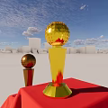 Decorative Ornament Set With Gold Silver Trophies On Red Draped Platform Against Blue Sky