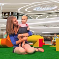 Colorful Playground Equipment With Curved Stepped Structures On Green Turf In Shopping Mall For Kids
