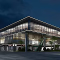 Modern Sales Office Building With Glass Curtain Walls Nighttime Lighting And Palm Trees At Entrance