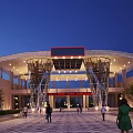 Modern Entrance Gate With Curved Roof Glass Metal Structure Nighttime Lighting And People On Plaza