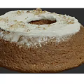 Brown Bundt Cake With White Frosting And Crumbled Toppings On Top