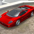 Sleek Red Sports Car With Black Roof Alloy Wheels On Dirt Ground