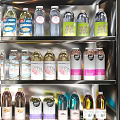 Assorted Bottled Beverages Displayed in Refrigerator with Various Flavors and Colors