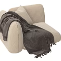 Cozy Beige Armchair Featuring Soft Cushion And Dark Gray Fringed Blanket