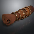 Human Hand Fist Wearing Multiple Golden And Brown Bracelets On Dark Background