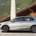 Silver Volkswagen Hatchback Parked Outdoor Near Scenic Buildings And Greenery View