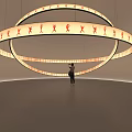 Interactive Circular Art Installation Featuring Orange Human Figures And Suspended Illuminated Rings 3d model