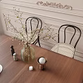 Modern Wooden Dining Table Set with Black Woven Back Chairs Vase White Flowers Coffee Cups
