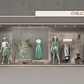 Modern Shop Window Display With Mannequins Dressed In Green Dresses And Decorative Plant