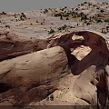 Natural Red Sandstone Rock Arch With Surrounding Desert Vegetation And Landscape