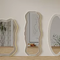 Different Shaped Gold Framed Mirrors With Plant Reflections On Light Wall And Wooden Floor
