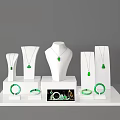 Green Jewelry Display Featuring Necklaces Pendants Bracelets On White Mannequin Stands