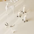 White Deer Decor With Glass Candle Holders And Lit Candles On Metal Stands