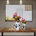 Blue and white porcelain vases with red yellow flowers on wooden table and calligraphy painting