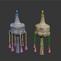 Two Traditional Sculptural Carvings With Ornate Tops Intricate Patterns And Hanging Tassels